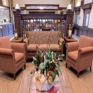 A cozy living area featuring a sofa, two armchairs, and a coffee table with floral decorations.