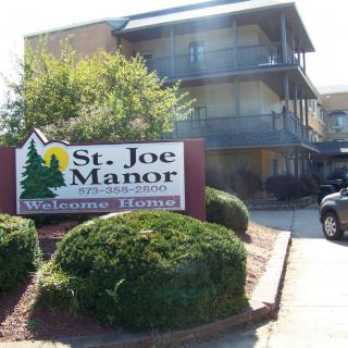 A multi-story building with a sign reading 'St. Joe Manor'.