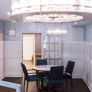 A modern dining area with stylish chandeliers and a round table surrounded by chairs.