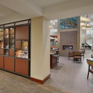A spacious and modern hotel lobby featuring a welcoming reception area and decorative display cabinets.