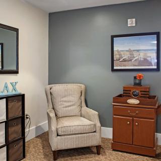 A cozy living room corner featuring an armchair, decorative items, and a relaxing ambiance.