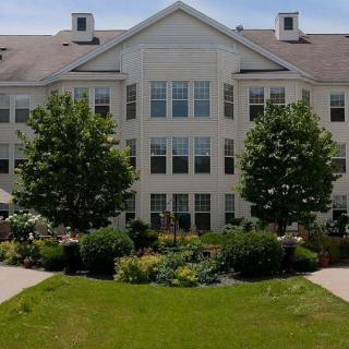 A well-maintained residential building surrounded by lush gardens and greenery.