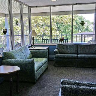 A cozy lounge area with sofas, chairs, and large windows letting in plenty of natural light.