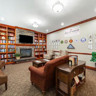 A cozy library with a fireplace and bookshelves, designed for relaxation and reading.