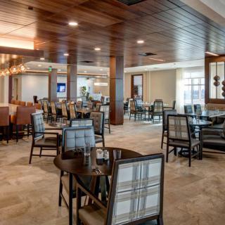 A modern restaurant dining area with tables and chairs, featuring stylish interior decor.