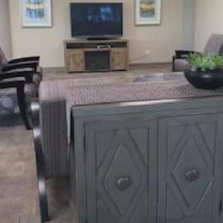 A modern living room with a TV, decorative cabinet, and seating area.