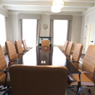 A spacious conference room with a long table and comfortable chairs.