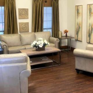 A cozy living room with a set of beige sofas, a coffee table, and decorative wall art.