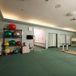 A spacious gym featuring racks of medicine balls and exercise equipment.