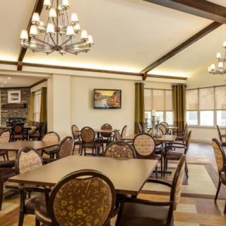 A modern dining room with elegant chandeliers and neatly arranged tables and chairs.
