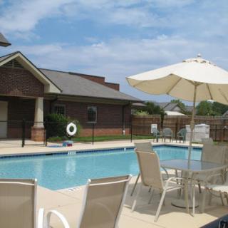 A serene poolside view featuring lounge chairs and umbrellas, perfect for a relaxing day under the sun.