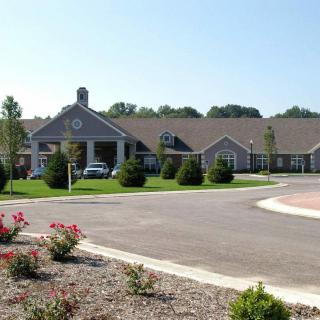 A spacious building surrounded by a landscaped area with a parking lot and plants.