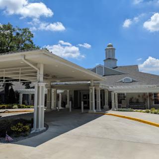 A modern building entrance with a covered walkway under a clear blue sky.