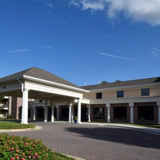 A large building with a covered entrance and clear blue sky.