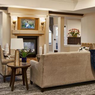 A cozy living room with a beige sofa, fireplace, and elegant decor.
