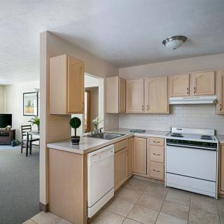 A modern kitchen interior with wooden cabinets and essential appliances.