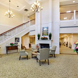 A spacious and elegantly decorated lobby with comfortable seating and a grand staircase.