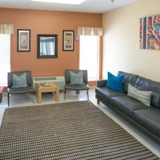 A well-lit living room with a sofa, chairs, and decorative elements.