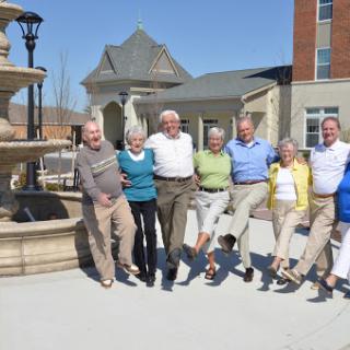 A joyful gathering of friends enjoying a sunny day by the fountain.