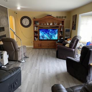 A cozy living room with a large TV and comfortable seating.