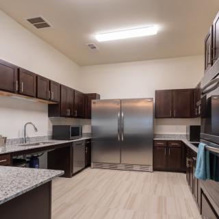 A modern kitchen with stainless steel appliances and dark wood cabinets.