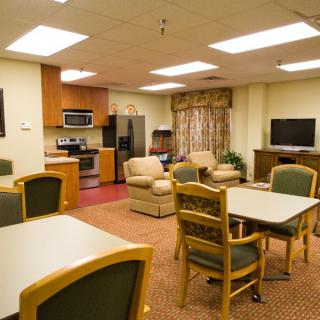 A cozy living area with an open kitchen, comfortable seating, and a television.