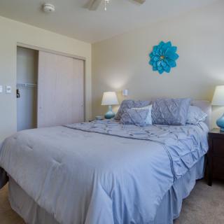 A cozy bedroom with blue-themed decor and neatly arranged furnishings.