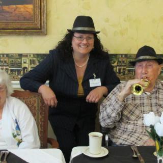 A group of people wearing hats, enjoying a celebration indoors.
