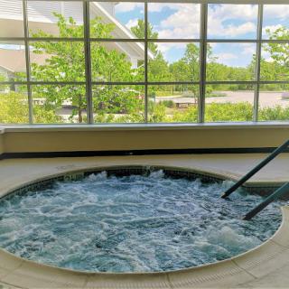 A serene hot tub experience, surrounded by natural light and a picturesque view.