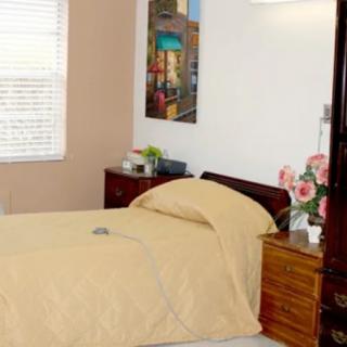 A cozy bedroom with a neatly made bed, nightstand, and decorative elements.