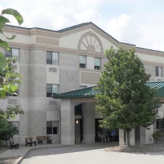 A hospital building with an entrance surrounded by trees.