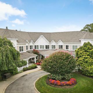 A large mansion with a well-maintained garden and circular driveway.