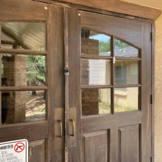 A wooden double door with glass panels, serving as an entrance.