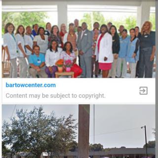 A group of medical professionals pose for a photo outside a healthcare facility.