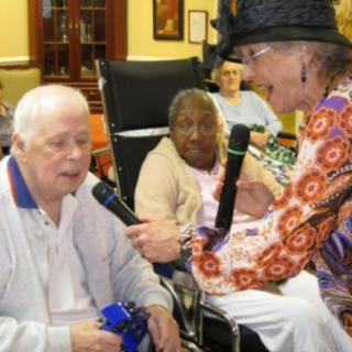 Elderly individuals engaging in a lively interaction at a nursing home.