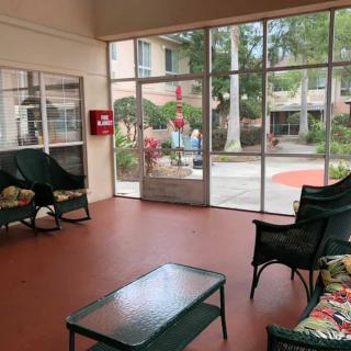 A lobby with comfortable seating and large glass doors providing a view of the outdoors.