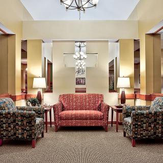 A cozy living room set with a sofa, armchairs, and decorative lamps.