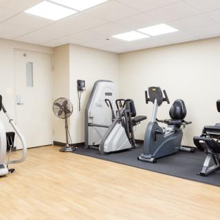 A small gym room with various exercise machines.