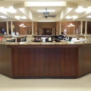 A spacious office reception area with a wooden counter and ample lighting.