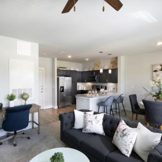 A modern living space with an open floor plan, featuring a stylish kitchen and comfortable seating area.