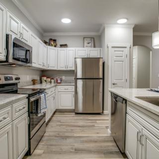 A modern kitchen featuring stainless steel appliances and white cabinetry.