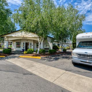 A small white building with a bus parked outside on a sunny day.