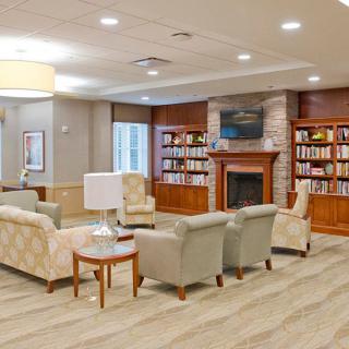 A cozy library-style living room with comfortable seating and a fireplace.