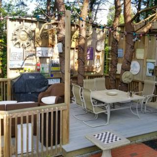 A cozy outdoor patio with seating and decor surrounded by trees.
