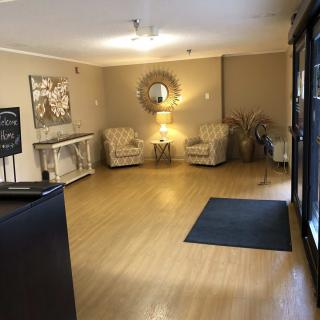 A cozy lobby area with chairs, a mirror, and artwork on the walls.