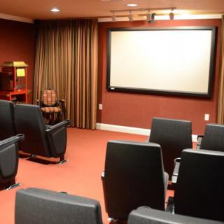 A cozy home theater setup with a large projector screen and comfortable seating.