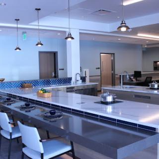 A modern kitchen space featuring sleek countertops, stylish barstools, and contemporary lighting.