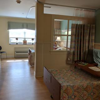 A view of a patient room in a hospital, showcasing the spacious layout and natural light.