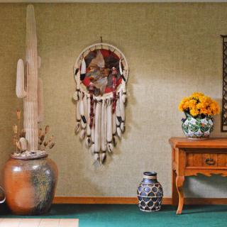 A cozy room with a dreamcatcher, vases, and flowers.
