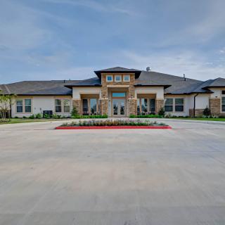 A spacious residential building with a stone facade and well-maintained landscaping.